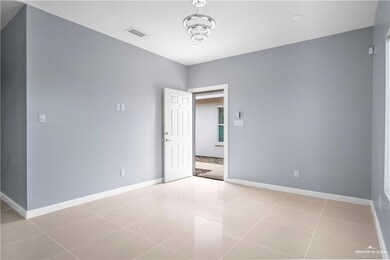Spare room with a chandelier and light tile patterned flooring