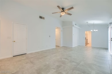 Unfurnished living room with ceiling fan, a chande