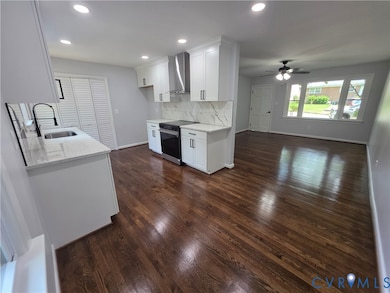 Kitchen featuring light stone counters, electric range, dark wood-style floors, recessed lighting, and white cabinets