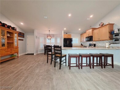 Kitchen with a peninsula, black appliances, light
