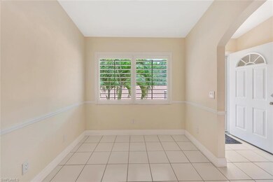 Empty room featuring arched walkways and light tile patterned floors