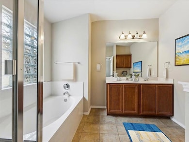 Full bathroom featuring a garden tub, double vani