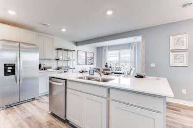 Gorgeous cabinets with quartz countertops, beautiful stainless appliances and vented micro-hood to the outside. (Model photo, colors may vary.)