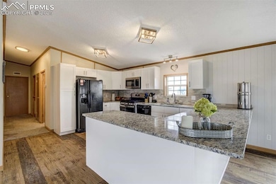 Kitchen with black appliances, a sink, crown moldi