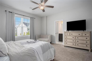 Bedroom with ensuite bath, light carpet, and ceili