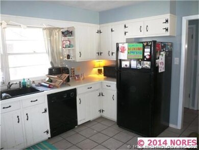 Large window overlooking front yard above the sink