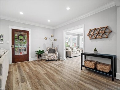 Wood floored entryway featuring crown molding