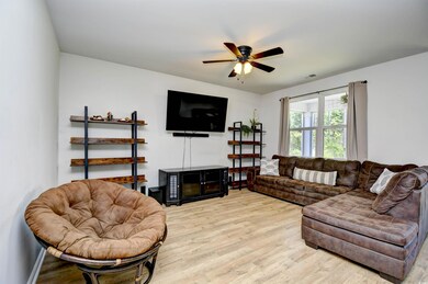 Living room featuring light wood-type flooring and ceiling fan