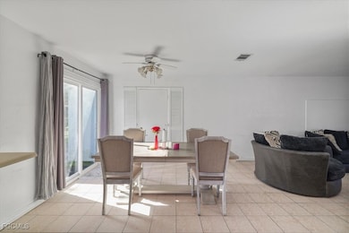 Dining space featuring light tile patterned floors and a ceiling fan