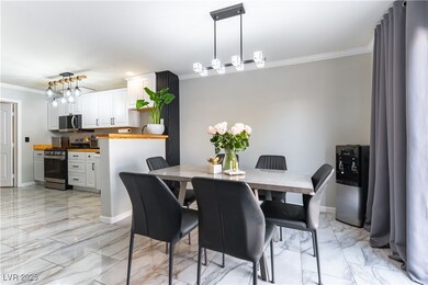 Dining area with crown molding, light marble finis