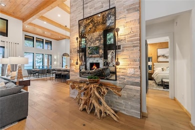 Living room featuring a fireplace, wood-type flooring, recessed lighting, 15ft ceilings, and wood ceiling with exposed beams