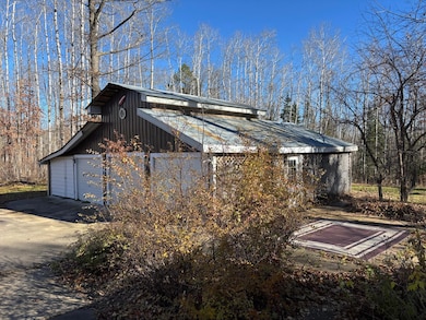 A garage view from the main entrance to the home. Lots of bushes and land scaping.