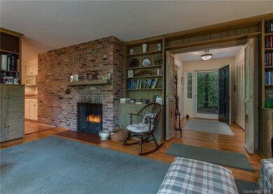 Gas log fireplace in Den with built-ins and book s
