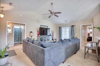 Living room featuring light colored carpet, vaulte