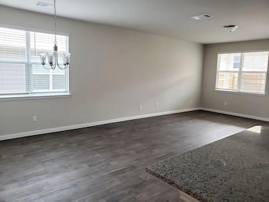 Unfurnished room with a chandelier and dark wood-style flooring