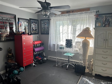 Office with crown molding, ceiling fan, and a baseboard heating unit