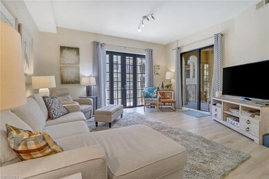 Living room with french doors, light hardwood / wood-style flooring, and track lighting