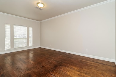Spare room with crown molding and dark hardwood / 