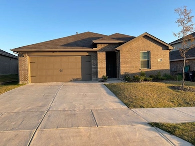 View of front of house with brick siding, concrete driveway, a front yard, and an attached garage