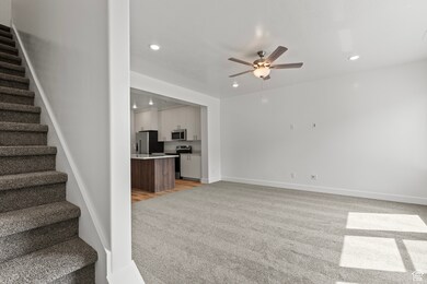 Unfurnished living room with stairs, light colored carpet, recessed lighting, and ceiling fan