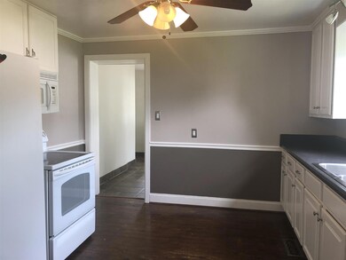 The kitchen has newer white cabinets