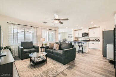 Living area featuring a ceiling fan, light wood-style floors, and recessed lighting