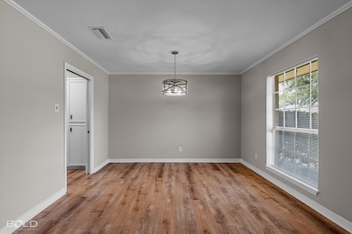 Unfurnished dining area featuring crown molding, light wood-style flooring, and a chandelier