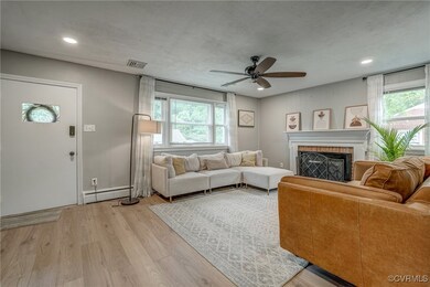 Living room featuring a baseboard radiator, light hardwood / wood-style flooring, a healthy amount of sunlight, and ceiling fan