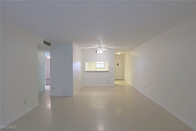 Spare room featuring ceiling fan, a textured ceiling, and light tile patterned floors
