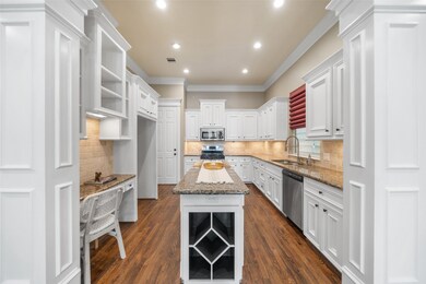 This spacious kitchen features elegant white cabin