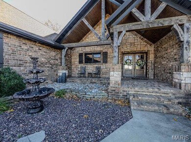 Property entrance with stone siding, french doors, and a patio area