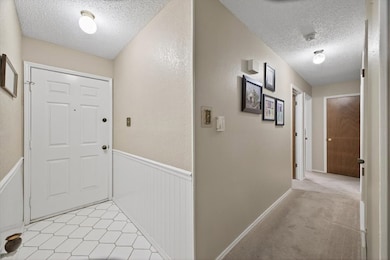 Hall featuring a textured ceiling