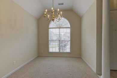Spare room with a notable chandelier, vaulted ceil