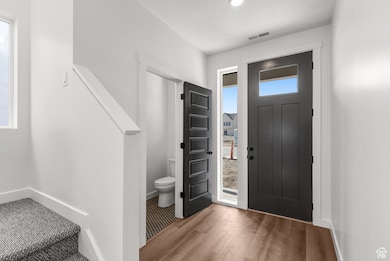 Entryway featuring baseboards and wood finished floors