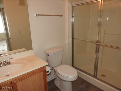 Bathroom with a shower stall, toilet, wood finishe
