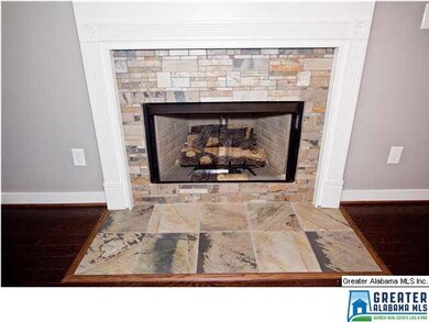 Tiled gas log fireplace in living room.