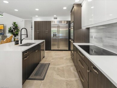 Kitchen with appliances with stainless steel finishes, a sink, light countertops, dark brown cabinetry, and a kitchen island with sink