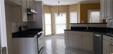 Kitchen featuring dark countertops, under cabinet 