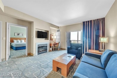 Living room featuring a glass covered fireplace, l