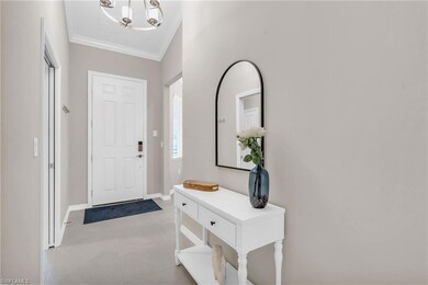Tiled foyer entrance with a chandelier and crown m