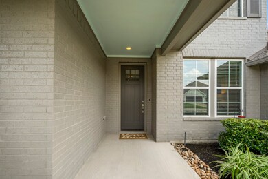 The covered front porch is a delightful spot to welcome guests. The craftsman-style door elevates the home's entryway.