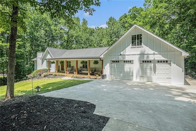 View of front of house with covered porch, board and batten siding, concrete driveway, a front lawn, and an attached garage
