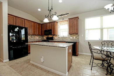 Kitchen with black appliances, backsplash, a cent