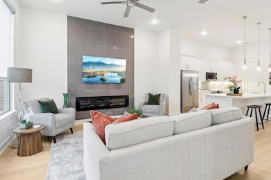 Living room featuring a large fireplace, ceiling f