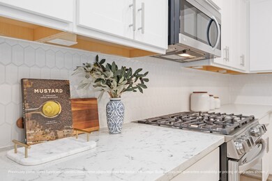 With elegant tilework, quartz counters, and a gas