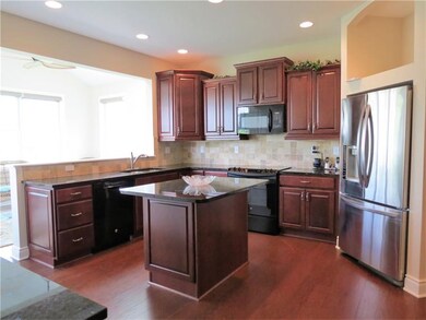 GOURMET KITCHEN OFFERING A CENTER ISLAND AND A FUL