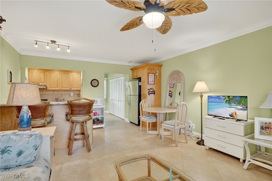 Living room featuring ornamental molding, a ceiling fan, and light tile patterned flooring