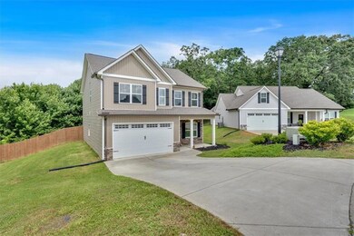 View of front of property with stone siding, concrete driveway, and an attached garage