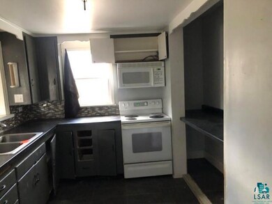 Kitchen with backsplash, sink, and white appliance