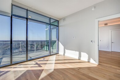 Unfurnished room with expansive windows and hardwo